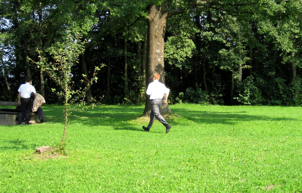 Joven misionero en Europa corre en un parque para entregar un Libro de Mormón a un hombre